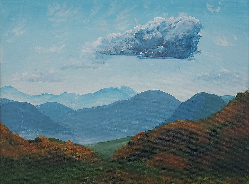 A scenic mountainous landscape unfolds at your feet. It is autumn and part of the shrubs and trees have already turned a rich orange colour. It’s a clear day with just a few whisps of cloud in the air. Except for one large cloud. It is casting a large shadow near the bottom of the valley.